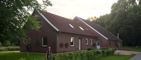 A brick building with a sloped roof and a small porch.