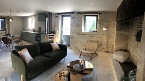 Ein modernes Wohnzimmer mit einer Couch, einem Couchtisch und einer Steinwand.