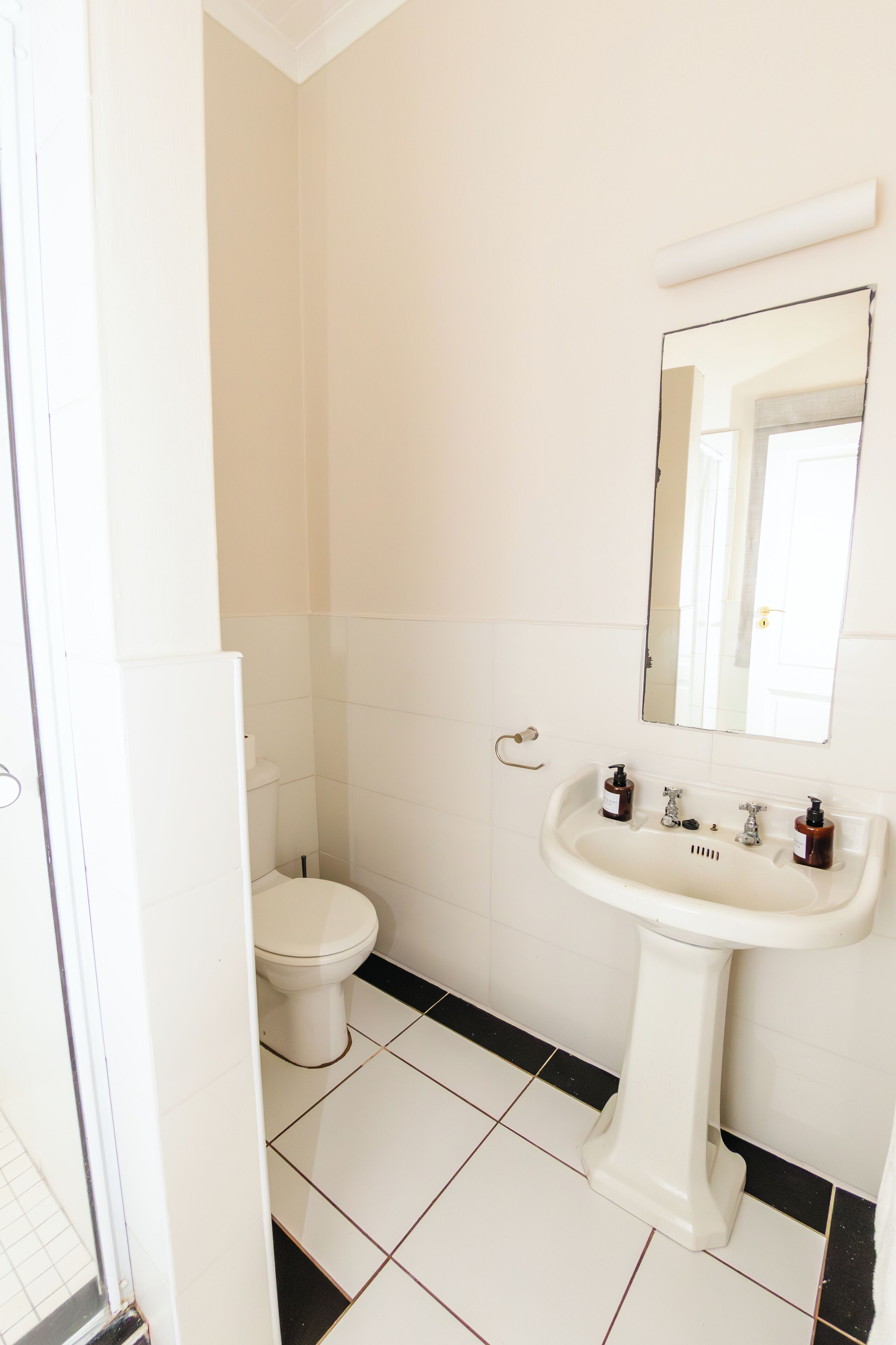 Un bagno con il water, un lavandino e uno specchio.