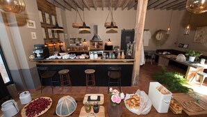 A kitchen with a central island, bar stools, and various kitchen appliances.