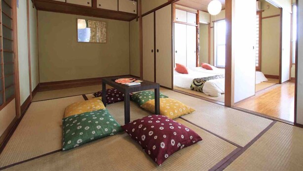 A traditional Japanese room with tatami flooring, a low table, and cushions. - Goraku Shinfukae (Osaka)