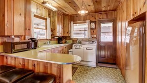 A wooden cabin kitchen with a central island, a stove, and a refrigerator. - 3993c Cedar Lake Tahoe 2 Bedroom Cabin by RedAwning (South Lake Tahoe)