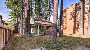A small, single-story wooden house with a green exterior and a porch. - 3993c Cedar Lake Tahoe 2 Bedroom Cabin by RedAwning (South Lake Tahoe)