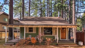 A house with a porch, a chimney, and a fenced yard. - 3993c Cedar Lake Tahoe 2 Bedroom Cabin by RedAwning (South Lake Tahoe)