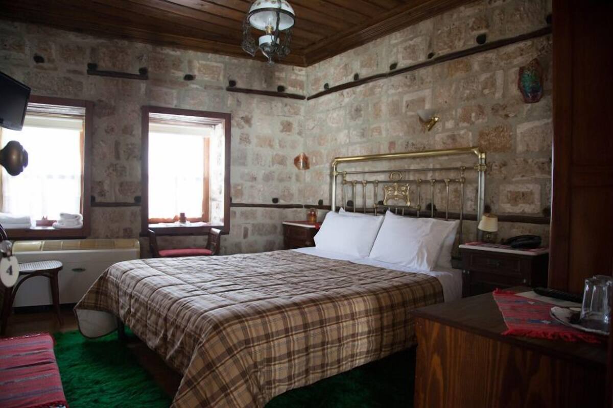 A room with a bed, a chair, a desk, a window, and a lamp.