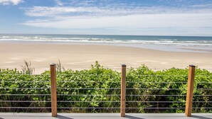 A beach with a metal fence and wooden posts, leading to a sandy shore with waves. - Ocean Front on Miles of Sandy Beach! Dog Friendly! (Yachats)