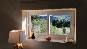 A room with a window overlooking a landscape, a lamp, and a vase on the windowsill. - Mas provençal La Serallère in the heart of olive groves (Venterol)