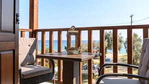 Eine Holzterrasse mit Korbmöbeln, einem Tisch und einer Laterne.
