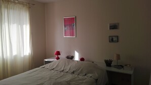 A bedroom with a bed, a nightstand with a lamp, a poster on the wall, and a window with curtains. - House with two terraces (south and north) and direct access to the bike path. (Messanges)