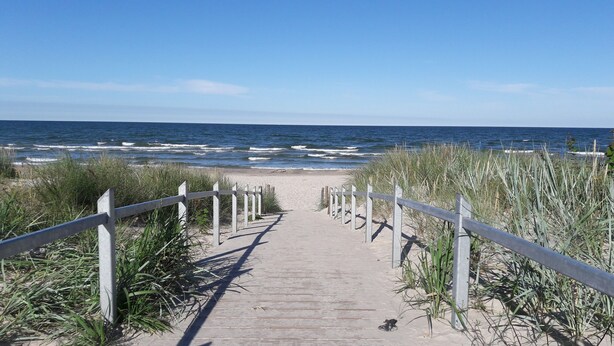 Un sendero de madera que conduce a una playa con vistas al océano.