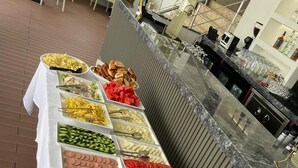 Una mesa de buffet con diversos alimentos y bebidas.