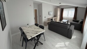 Un espacio habitable moderno con comedor, sofá y kitchenette.