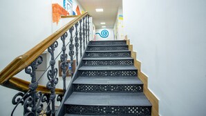 Una escalera con barandillas negras ornamentadas y escalones de madera.