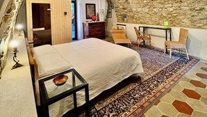 A bedroom with a stone ceiling, a bed, a desk, and a chair. - Residenza Liberty on the Lakefront Loft (Marone)