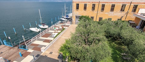 A waterfront hotel with a dock, boats, and a garden area.