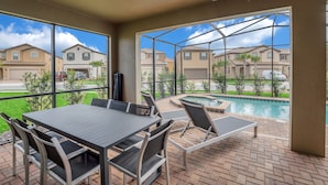 A patio area with a table and chairs, a pool, and a view of neighboring houses. - Private Pool Home w/Incredible Game Room! FREE Resort Access (Davenport)
