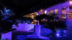 A building with a modern design, featuring a staircase leading to a bar area with seating. - La Villa Resort (Pieve a Nievole)