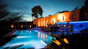 A swimming pool with a modern architectural building in the background. - La Villa Resort (Pieve a Nievole)