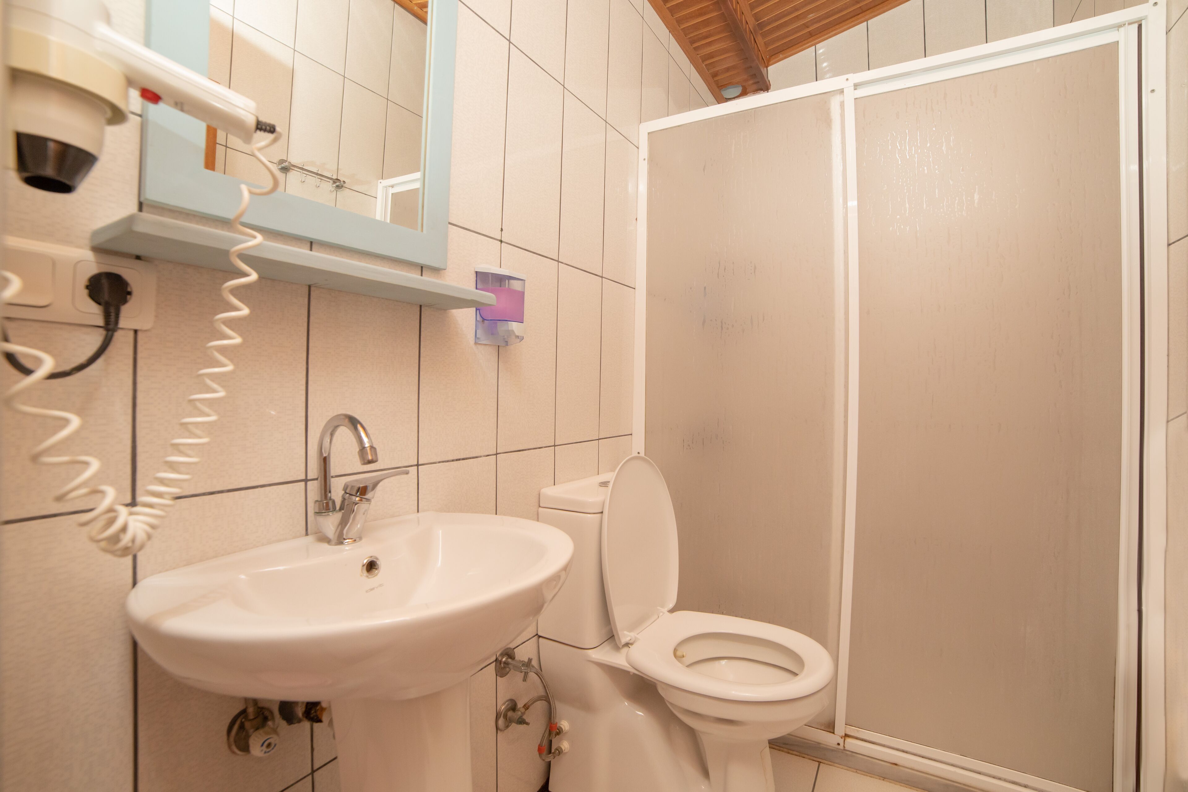 Un baño con lavamanos, inodoro y cabina de ducha.