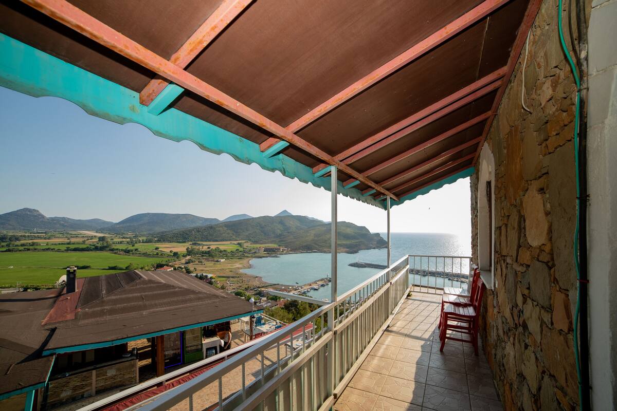 A balcony with a view of the sea and mountains.
