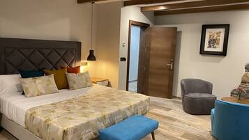 Un dormitorio moderno con una cama grande, un banco, una silla y una puerta de madera.