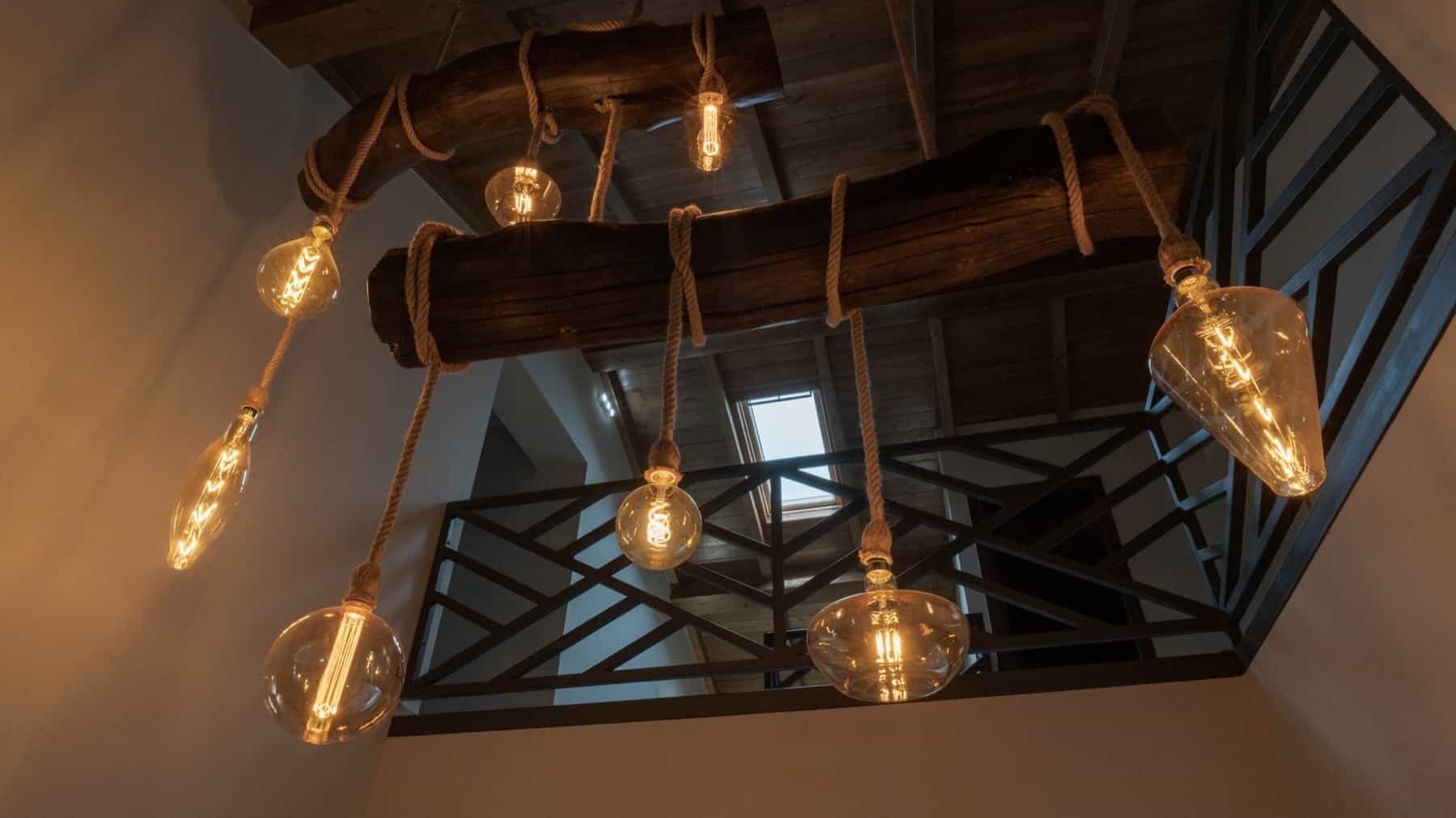 A ceiling with exposed wooden beams and hanging light fixtures.