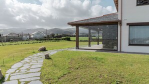 Una casa moderna con un sendero de piedra que conduce a un área exterior cubierta con puertas de vidrio.