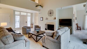 A spacious living room with a fireplace, a television, and comfortable seating.