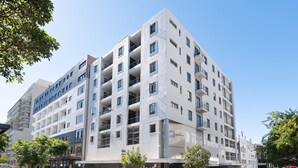 Un edificio de varios pisos con un estilo arquitectónico moderno, con balcones y ventanas amplias.