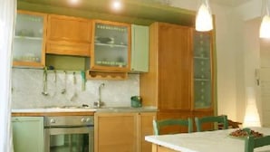 Eine Küche mit Holzausstattung, einer Spüle, einem Backofen und einem Esstisch mit Stühlen.