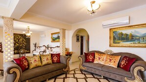 A spacious living room with two sofas, a chandelier, and a patterned floor. - Imagine Renting Your Own 5 Star Private Cyprus Villa on the Beach, Paphos Villa 1410 (Ayia Marina Chrysochous)