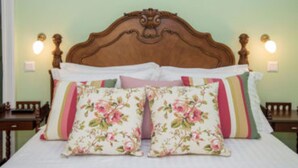 A bed with floral-patterned pillows and a wooden headboard. - Private Pool & Breathtaking Views, Corfu Villa 1000 (Corfu)