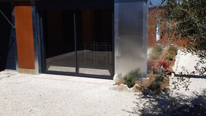Un bâtiment moderne doté d’une grande porte vitrée et d’une allée gravillonnée.