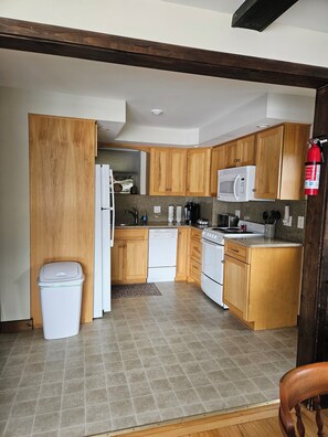 A kitchen with wooden cabinets, a microwave, a dishwasher, and a stove. - Beautiful Lake Winnipesaukee Waterfront! (Alton)