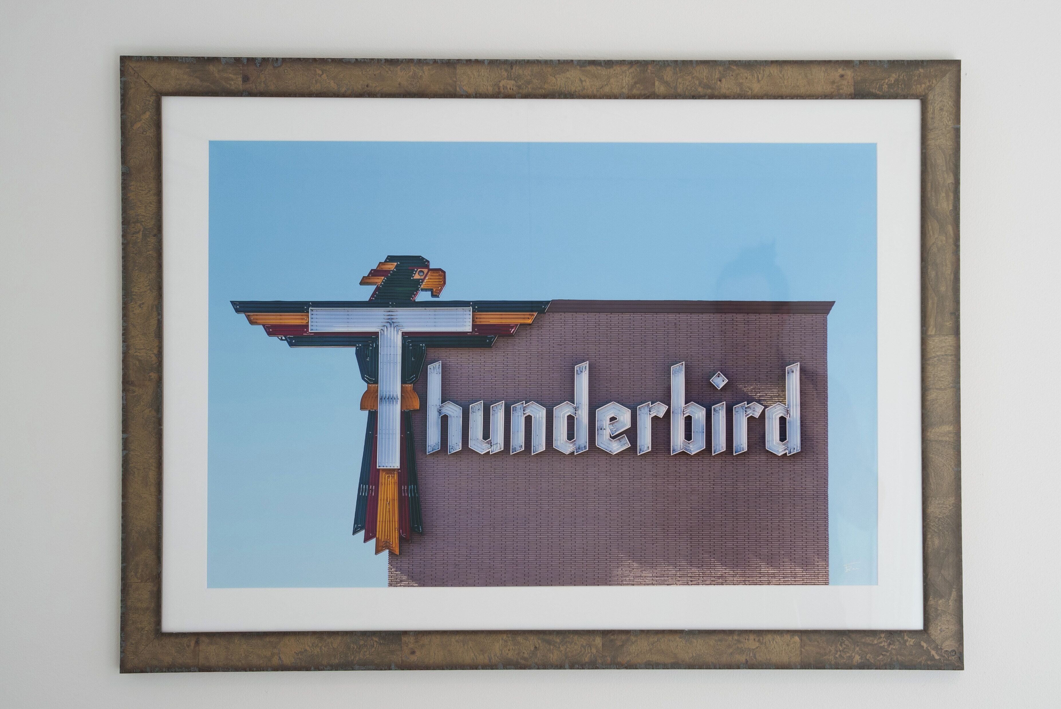 Un quadro incorniciato raffigura un edificio con un cartello che riporta la scritta "Thunderbird".