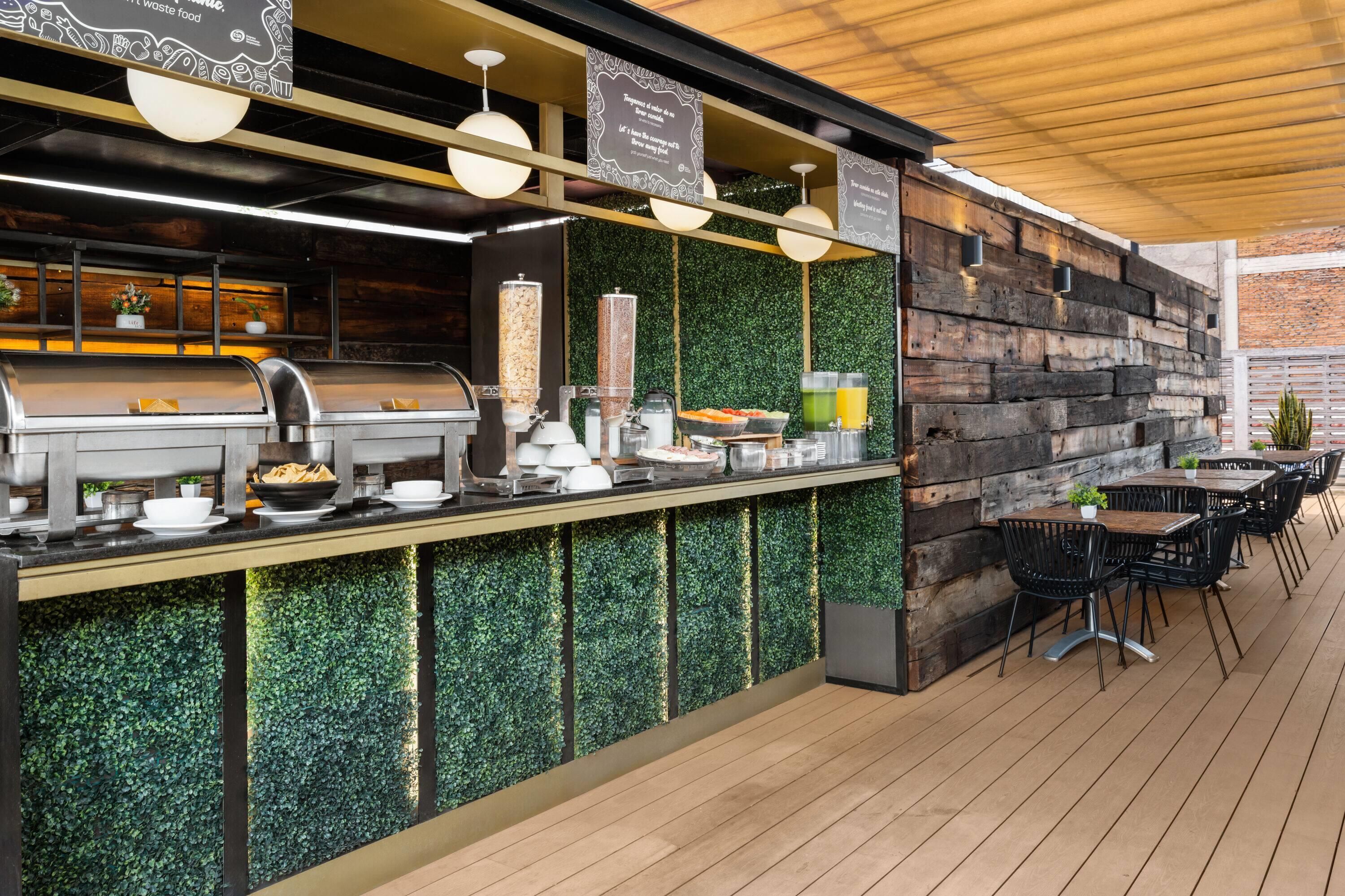 An outdoor bar area with a grill, food dispensers, and seating.