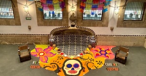 A room with a central altar, colorful decorations, and two chairs on either side. - Hotel MX mas centro CDMX, Trademark Collection by Wyndham (Mexico City)
