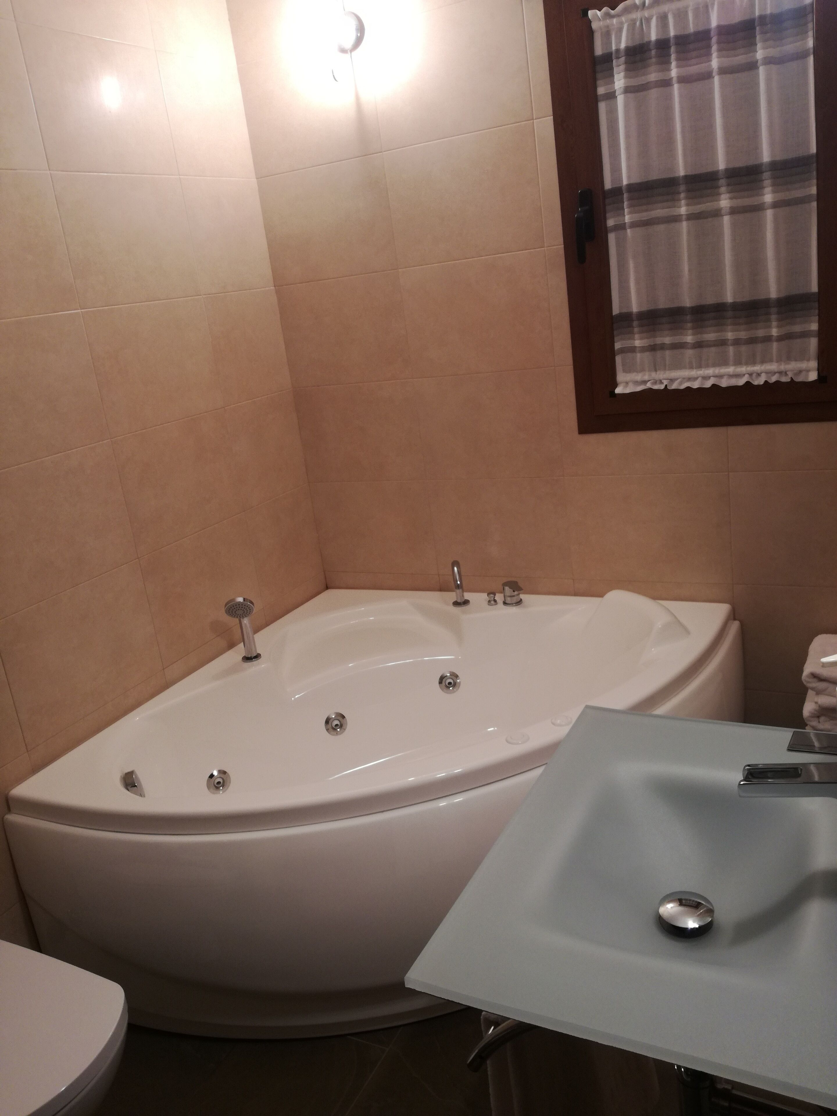Un baño con bañera, lavamanos e inodoro.