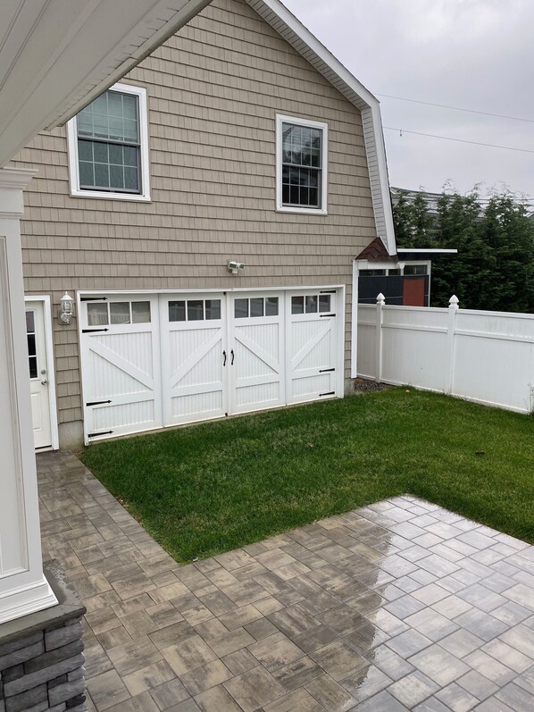 A house with a garage, a well-maintained lawn, and a paved driveway.