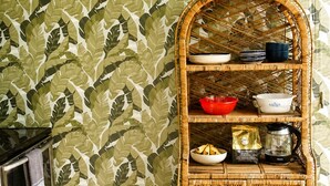 A kitchen with a leaf-patterned wallpaper, a wicker sideboard with dishes, and a stainless steel oven. - An Affordable Alternative to Expensive Accommodations in Poipu (Koloa)