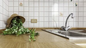 A kitchen with white tiled walls, a stainless steel sink, and a wooden countertop. - La Villa - Luxury Home (Configni)