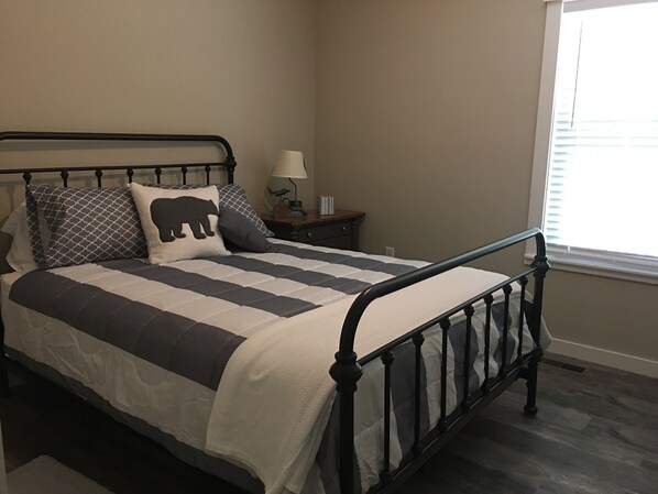 A neatly made bed with a striped bedspread and two pillows, one with a bear design. - Family Friendly Guest house-3 bedroom, 2 bath. Custom farm/craftsman (Mountain View)