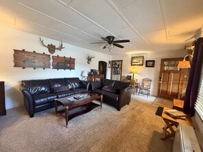 A living room with a sectional sofa, a coffee table, a ceiling fan, and a door with a window. - 0.6 miles to Downtown, 3.9 miles to RMNP, Hot Tub, Activity Shed! Far View Cabin (Estes Park)