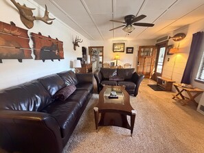 A living room with leather sofas, a coffee table, and wall-mounted animal skulls. - 0.6 miles to Downtown, 3.9 miles to RMNP, Hot Tub, Activity Shed! Far View Cabin (Estes Park)