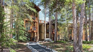 A lodge with a stone pathway leading to a wooden building surrounded by tall pine trees. - Unbeatable Location; Walk to Lift/Town/Trails; Heated Boot Dryer (Breckenridge)