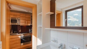 A modern kitchen with wooden cabinets, a microwave, and an oven.