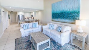 A spacious living room with white furniture, a large abstract painting, and a ceiling fan. - Gulf Front, 3 Bedroom Condo, Small Complex, Dune Allen Beach, Santa Rosa Beach (Santa Rosa Beach)