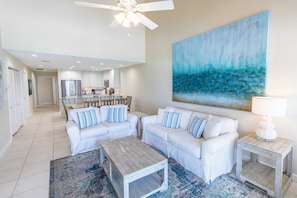 A spacious living room with white furniture, a large abstract painting, and a ceiling fan. - Gulf Front, 3 Bedroom Condo, Small Complex, Dune Allen Beach, Santa Rosa Beach (Santa Rosa Beach)