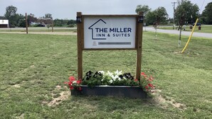 Skilt for The Miller Inn & Suites med et simpelt og overskueligt layout samt en kontakt-e-mailadresse.