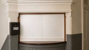 A corner of a room with a white wall, a grey wainscotted wall, and a door with a white frame.